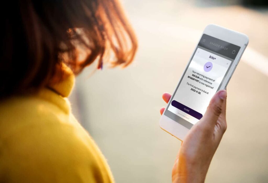 Women with mobile phone showing payments completed.