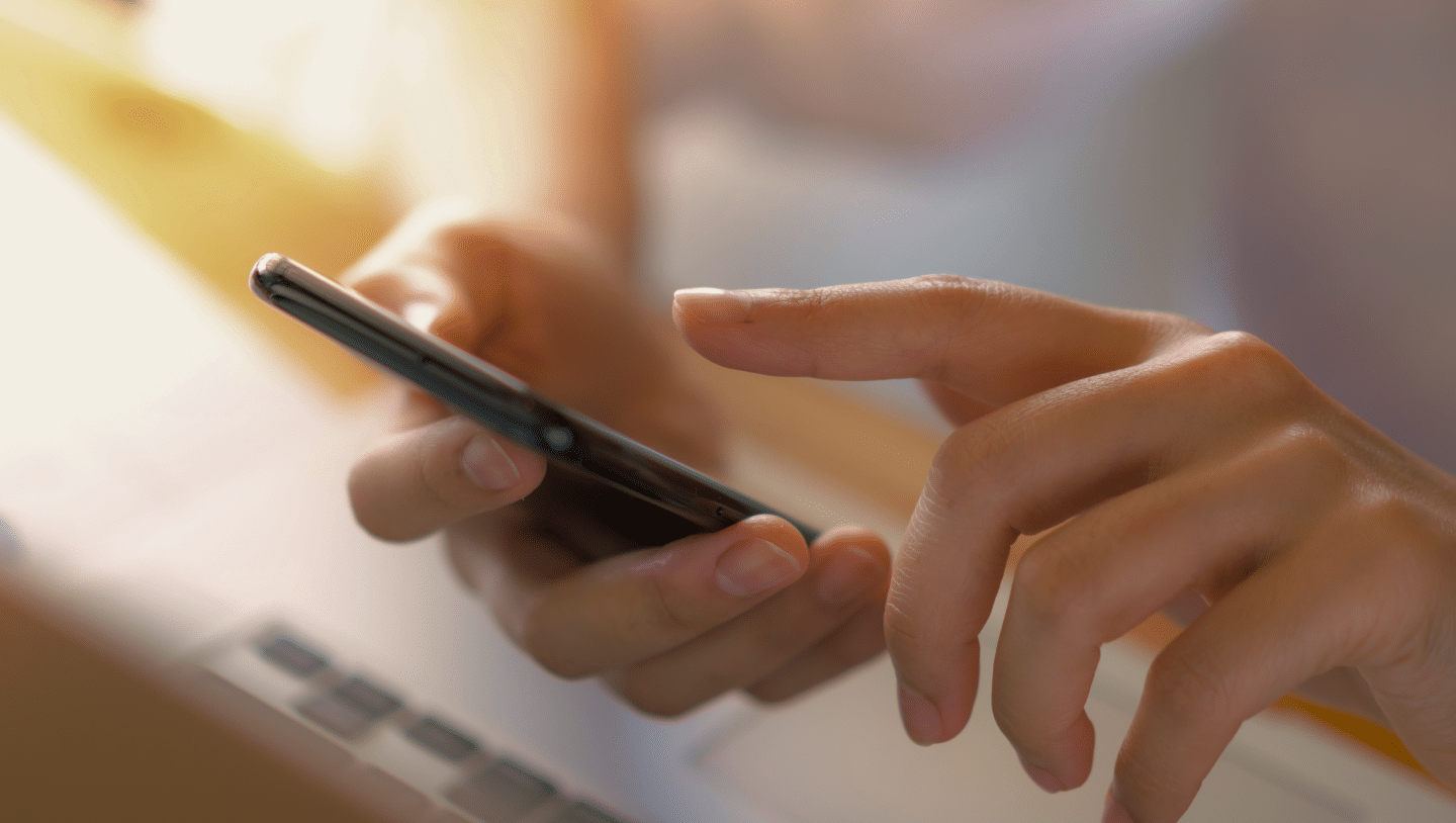 Nahaufnahme eines Smartphones, das in den Händen gehalten und bedient wird.