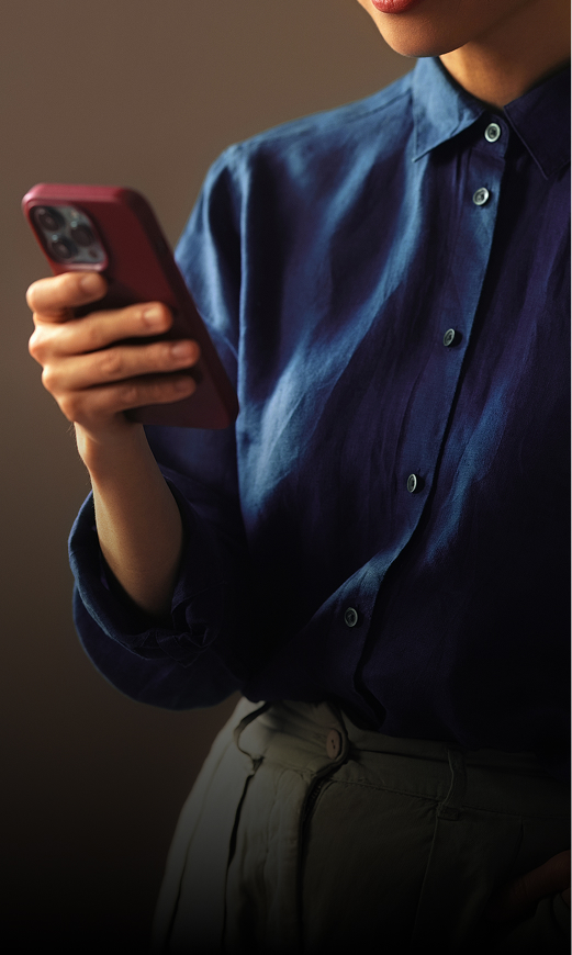 Person holding smartphone in casual attire to represent e-commerce