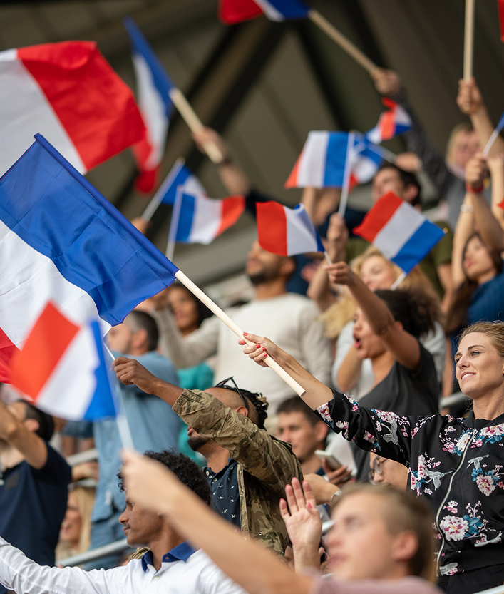 An image of French flags being flown at a sports match which uses Brite Payments