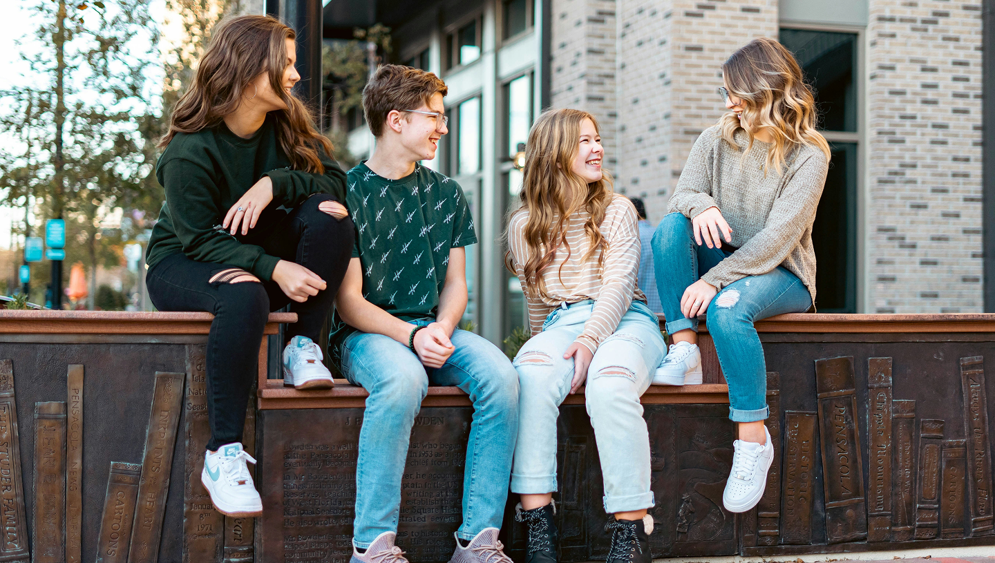 German Gen Z image showcasing German youth outside a college on a wall talking