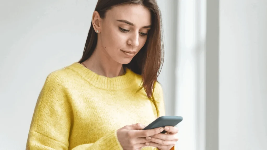Women who is interested in Open Finance holding a phone.