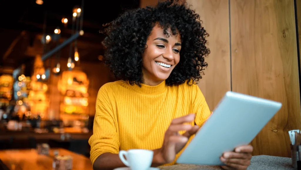 Woman with tablet smiling in cafe