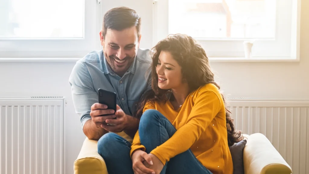 Couple with smartphone smiling