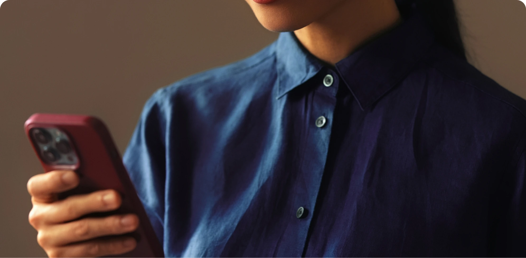 E-commerce hero image of woman in blue shirt holding phone